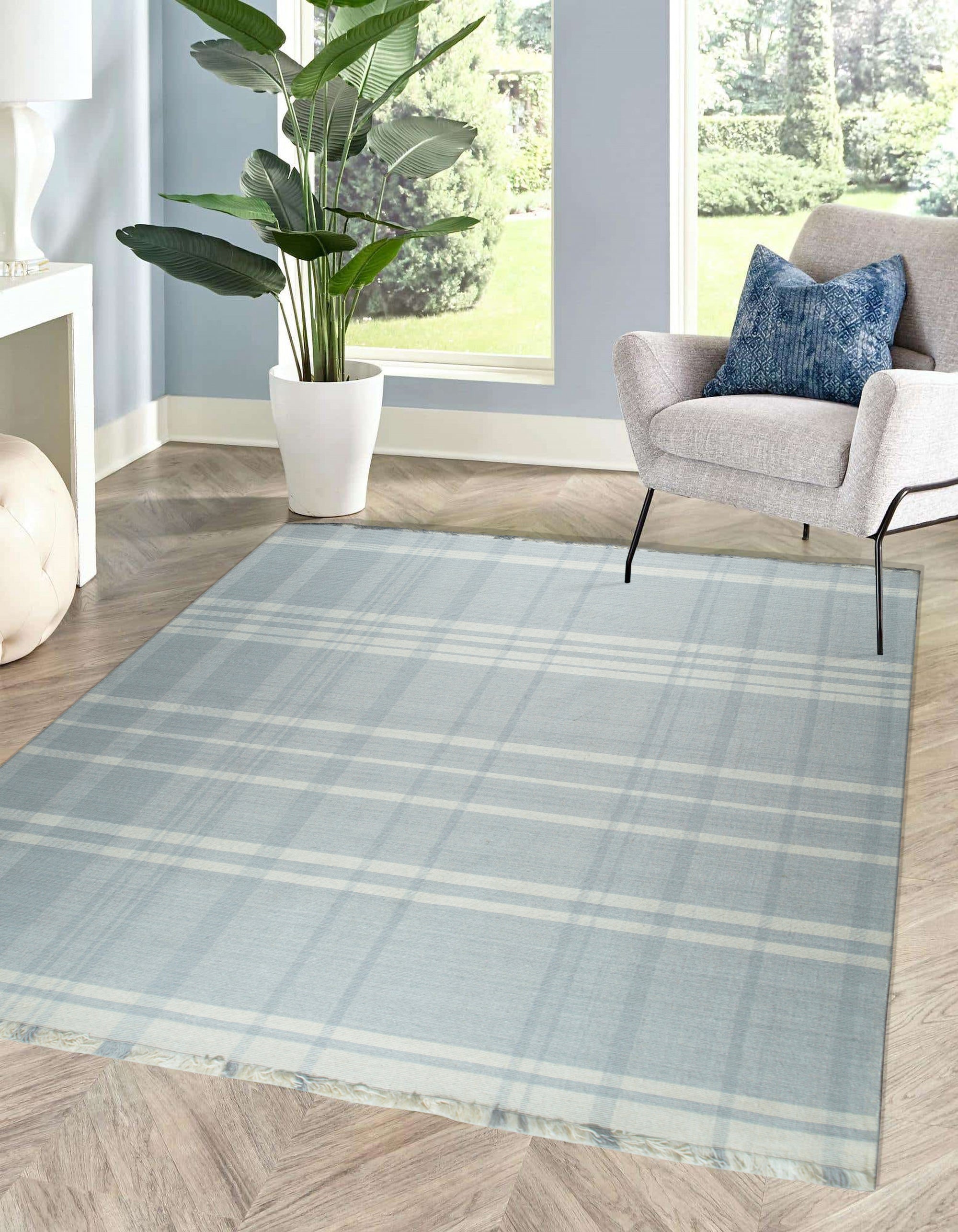 Dazzling Fiona White Flatweave Wool Rug, a bright, minimalist rug in a living room setting, its flatweave construction adding a subtle textural element to the light-filled space.