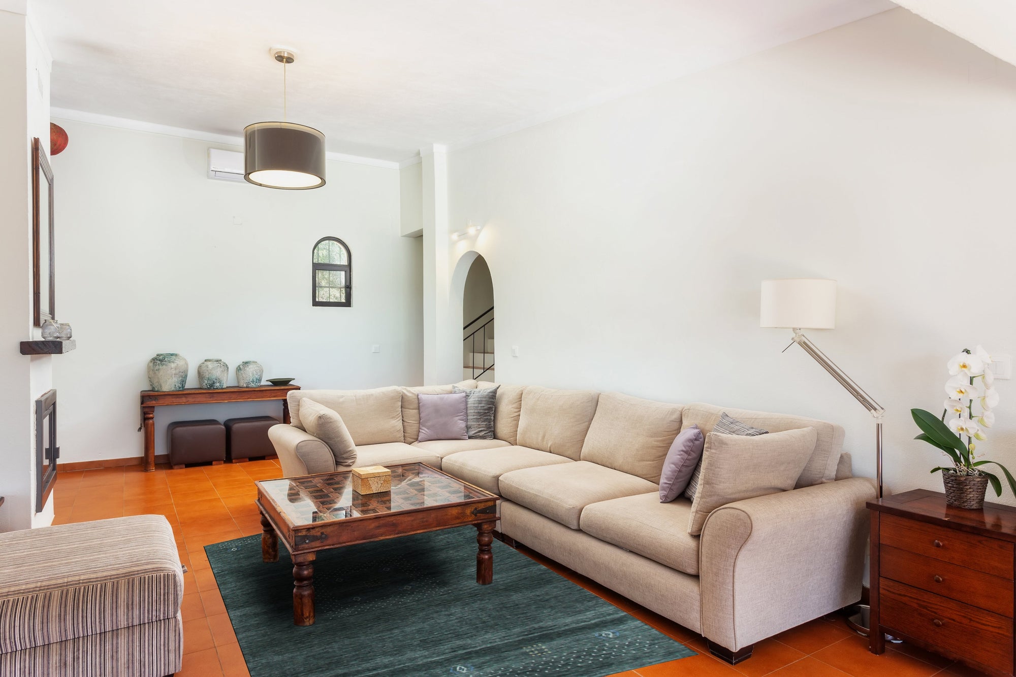 Freya Gabbeh Gray Handmade Wool Rug displayed in a bright, airy living room. Soft gray wool pile highlights a subtle geometric pattern. The rug grounds a seating area with a light-colored sofa and natural wood accents.