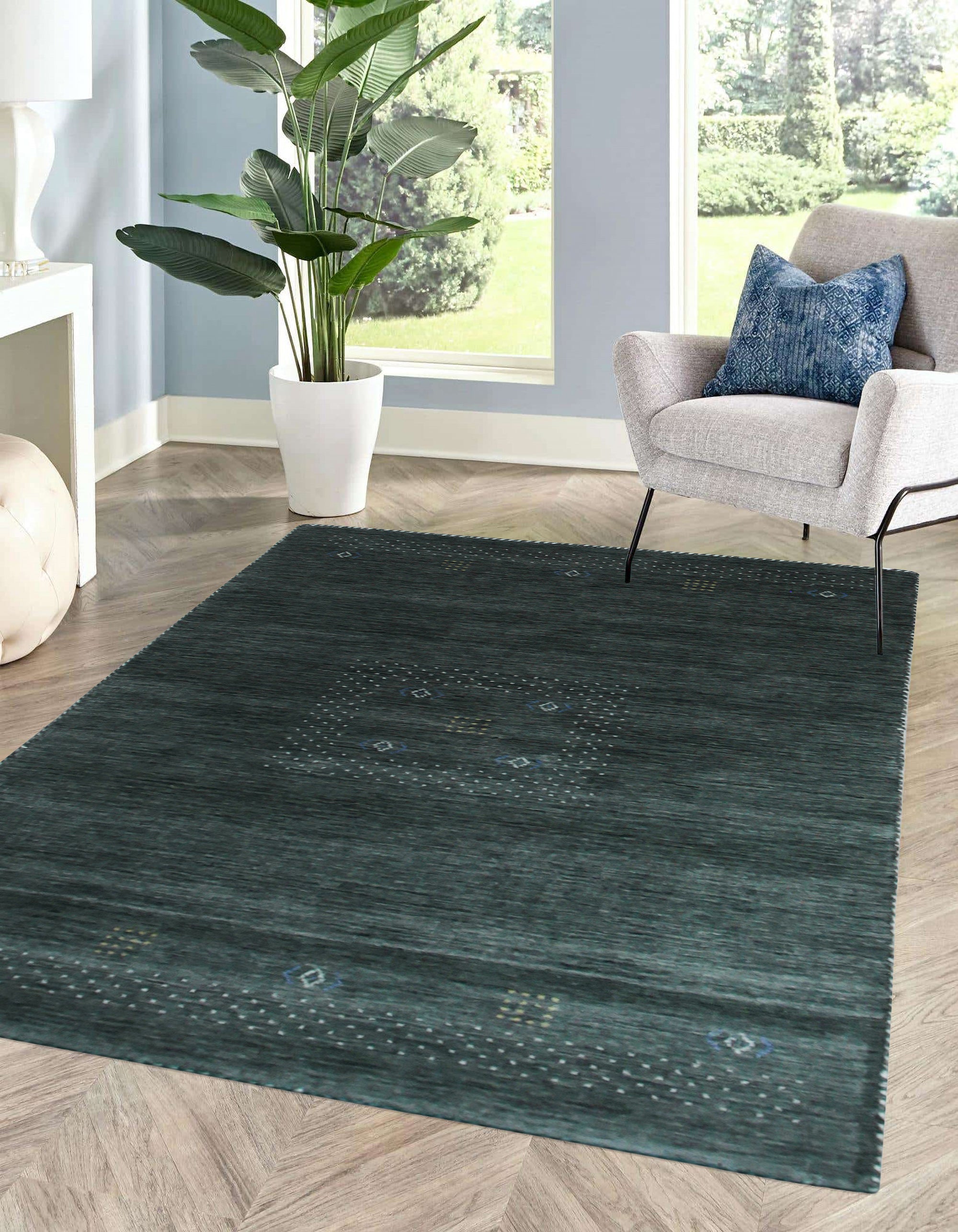 Freya Gabbeh Gray Handmade Wool Rug, showcasing a textured, handwoven pile with subtle variations in gray tones, lending a warm, inviting feel to a well-lit living room.