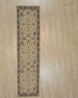 Charming Oushak ivory and blue hand knotted wool hallway runner rug shown full length on light wood flooring