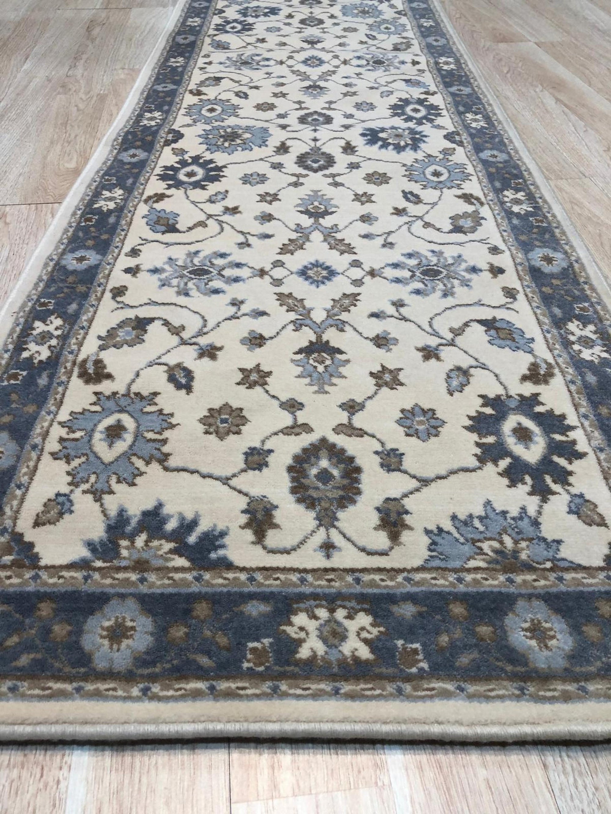 Close up of the ivory field and slate blue floral border on the Charming Oushak hand knotted wool runner rug