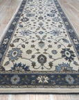 Close up of the ivory field and slate blue floral border on the Charming Oushak hand knotted wool runner rug
