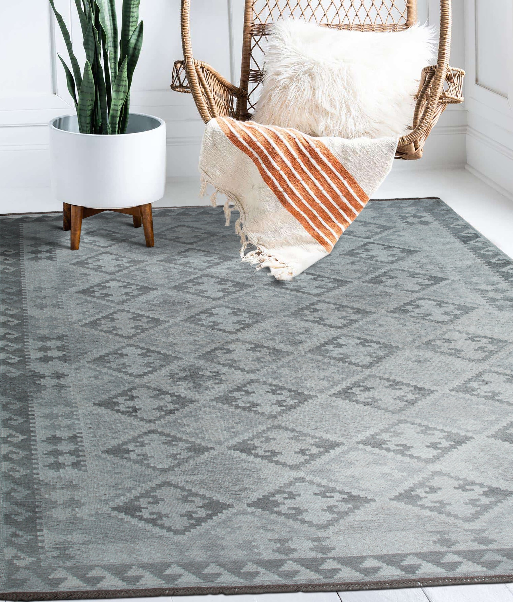 Brenda Para Gray Flatweave Wool Rug, showcasing subtle geometric patterns in soft grays, lying flat in a bright, modern living room setting, complementing a minimalist aesthetic.