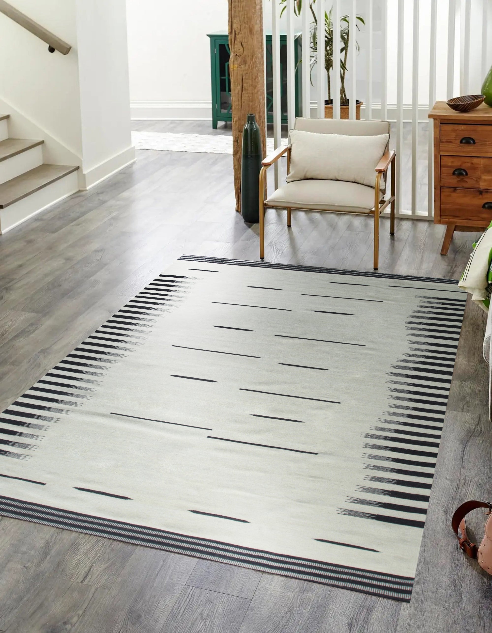 Sloane Majestic Gray Flatweave Wool Rug gracing a light hardwood floor in a modern living room. Subtle pattern in shades of gray adds depth without overwhelming the space. Flatweave construction suggests durability and low profile.