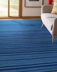 Trara Penelope Blue Flatweave Wool Rug, showcasing a modern living room with this blue wool rug adding a touch of textured comfort and contemporary style.