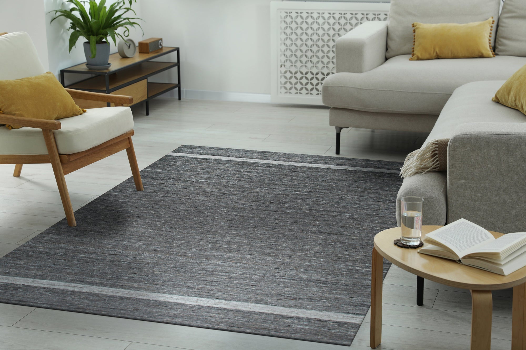 Cozy Inviting Gray Flatweave Wool Rug, blending seamlessly into a bright, modern living room with light wood floors and a neutral sofa. The flatweave construction is visible, adding subtle texture underfoot.