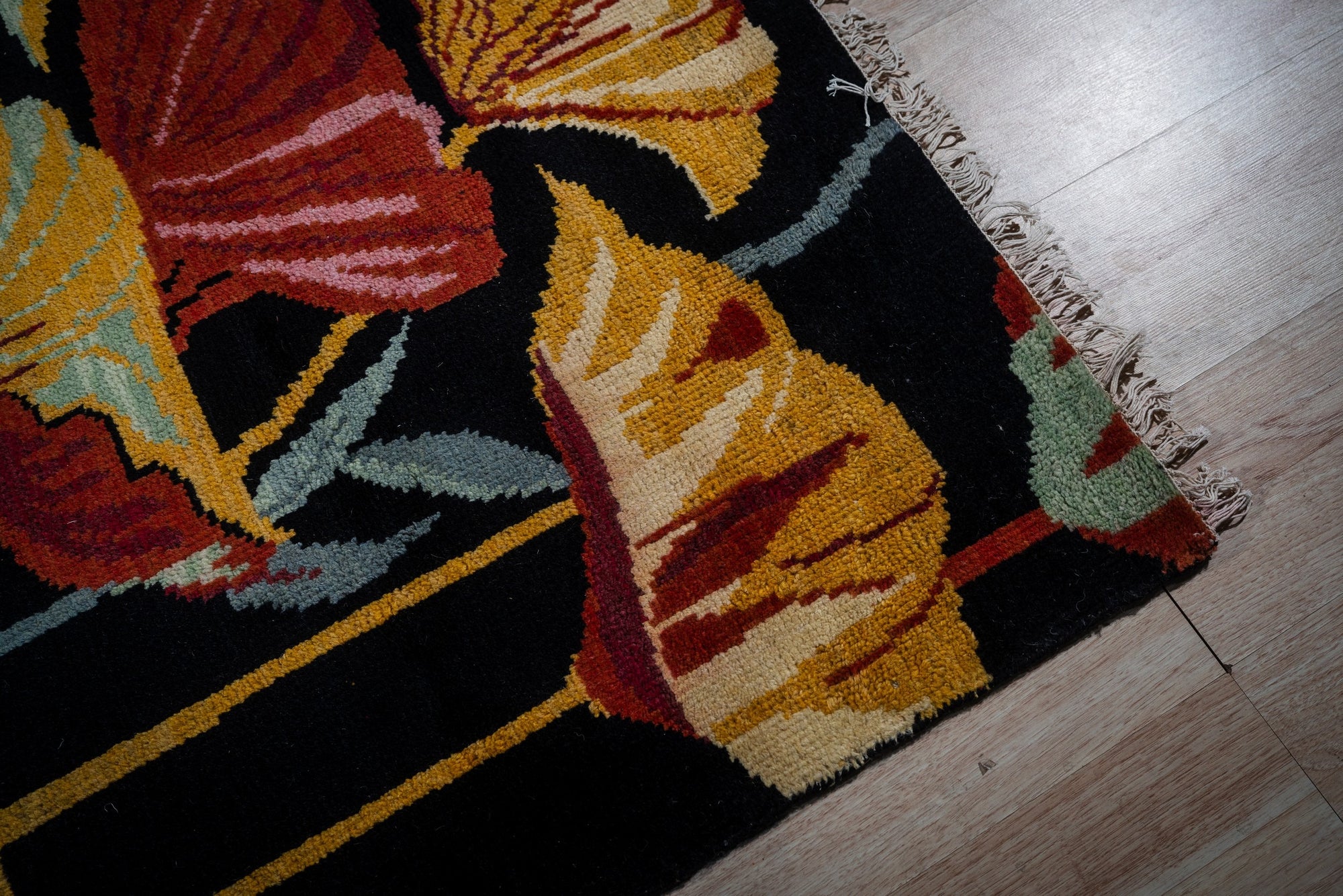 Black floral contemporary rug corner and fringe detail