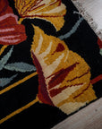 Black floral contemporary rug corner and fringe detail