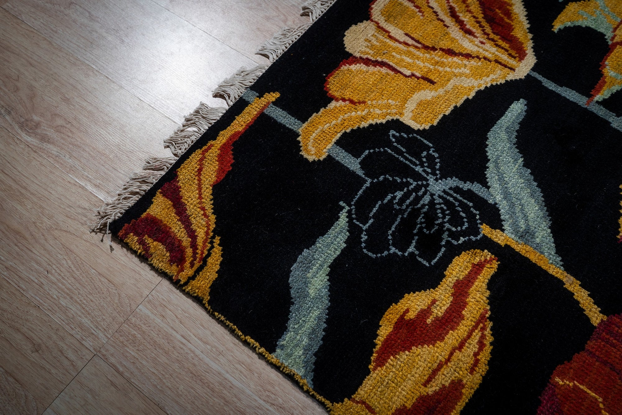 Black floral contemporary rug corner detail with gold blossoms