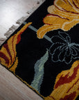 Black floral contemporary rug corner detail with gold blossoms