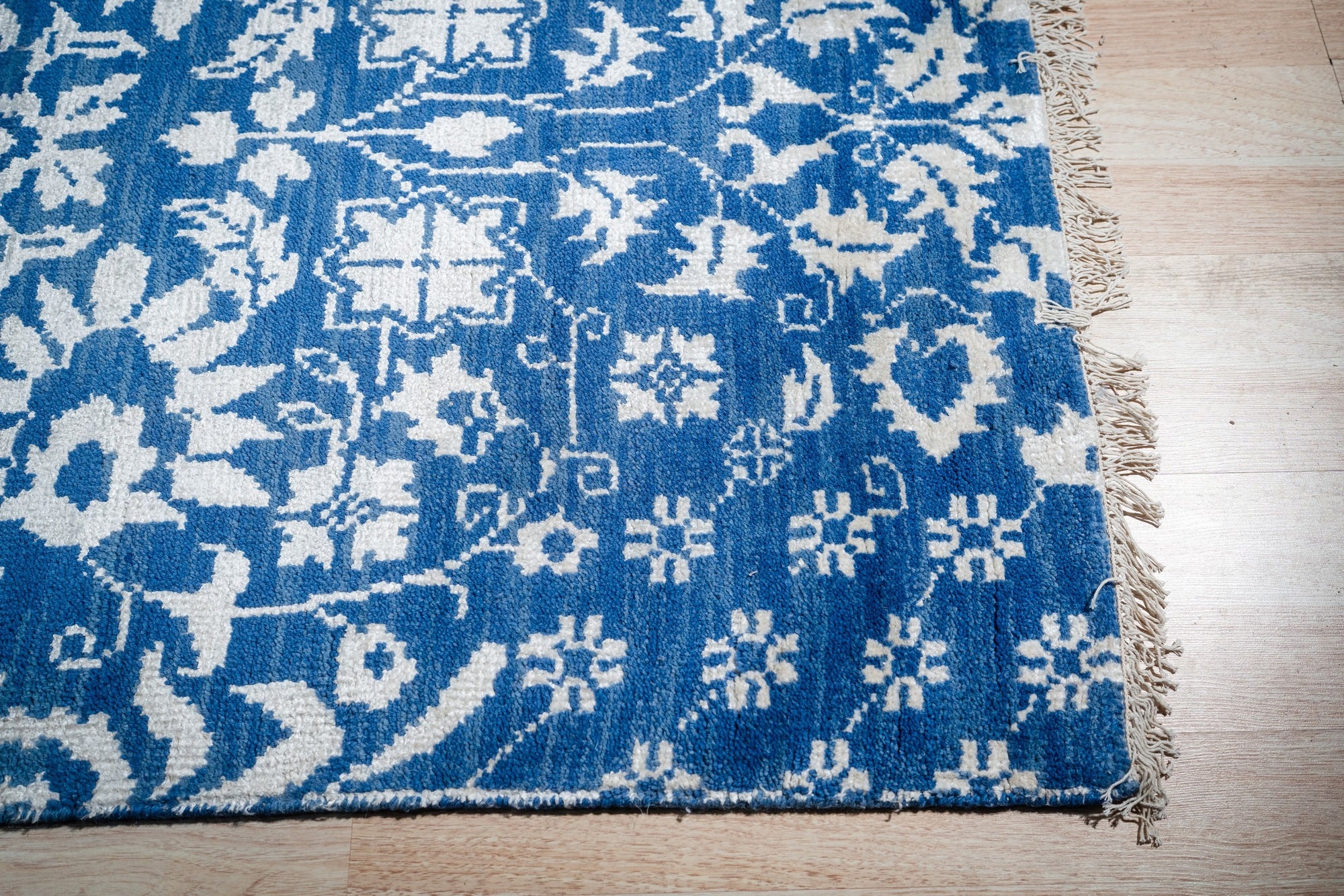 Blue ivory Oushak rug corner and fringe detail