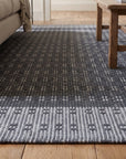 Clara Xena Charcoal Flatweave Wool & Cotton Rug in a living room