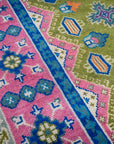 Green and fuchsia Kazak rug border and field close-up