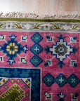 Green and fuchsia Kazak rug corner detail