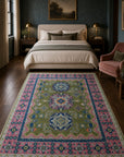 Green and fuchsia Kazak rug styled in a designer bedroom