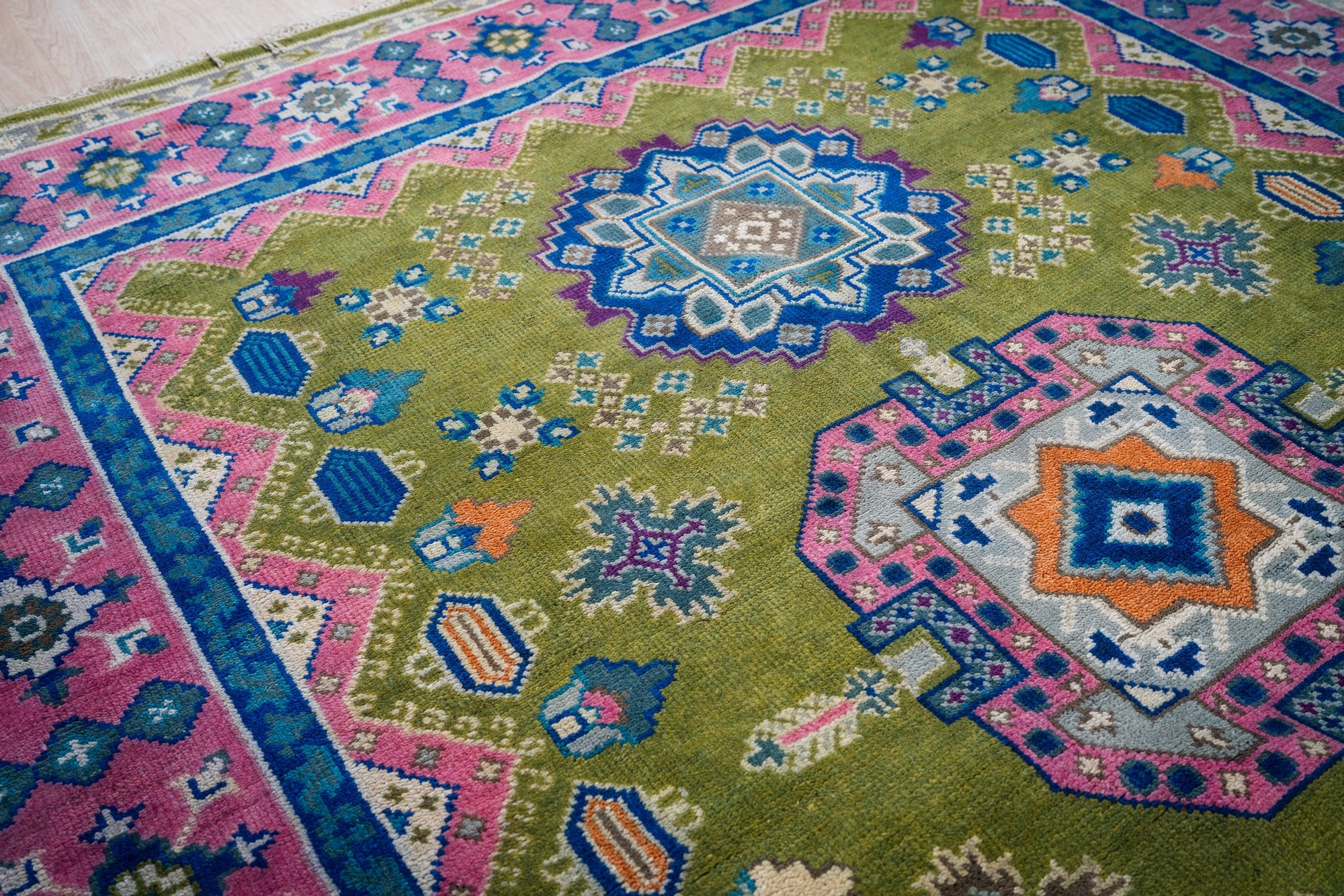Green and fuchsia Kazak rug medallion detail