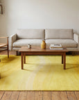 Inviting Ruby Yellow Hand Tufted Wool Rug in a living room