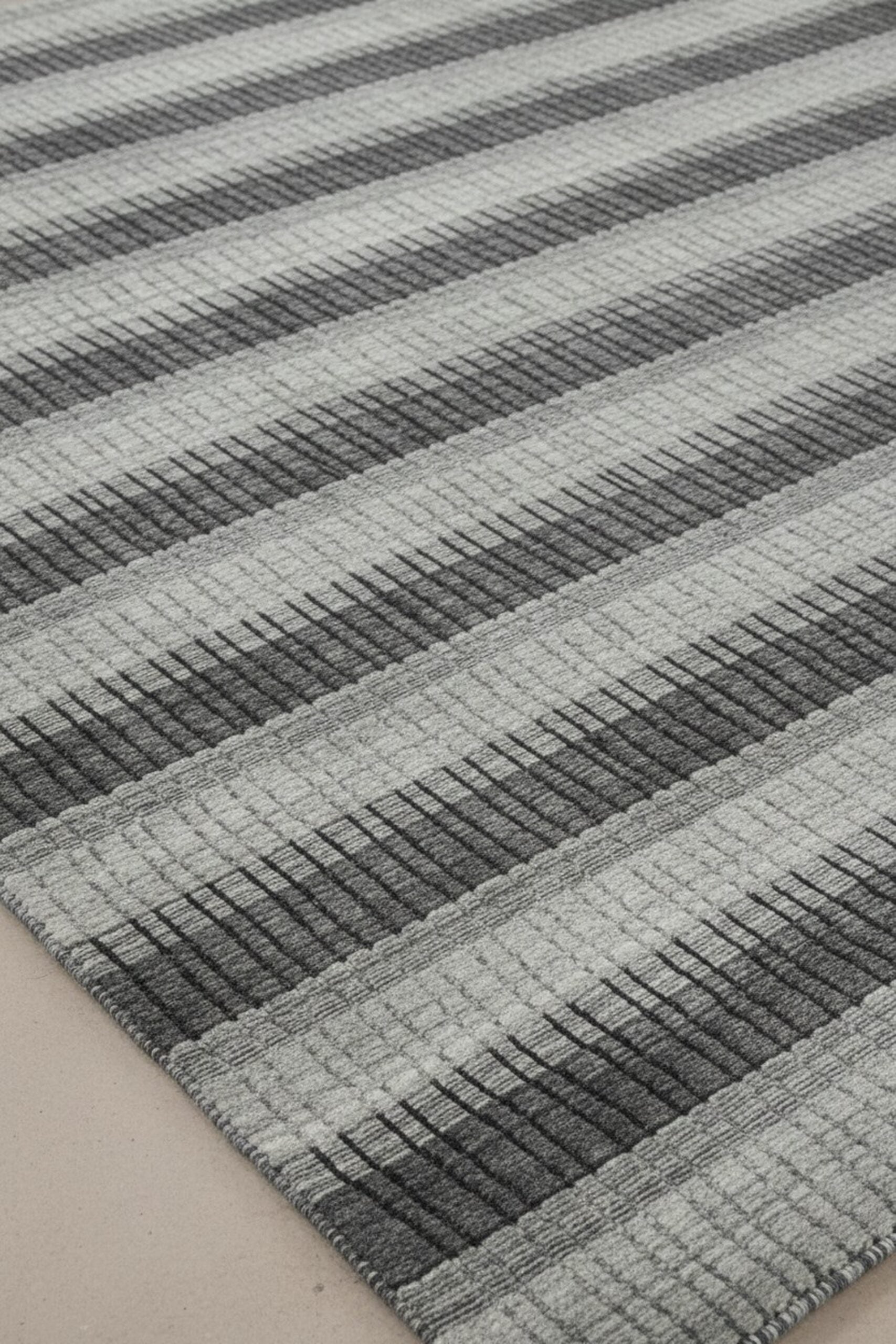 Gray contemporary geometric loom-check wool and viscose area rug styled in a living room