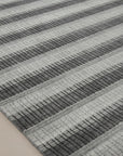Gray contemporary geometric loom-check wool and viscose area rug styled in a living room