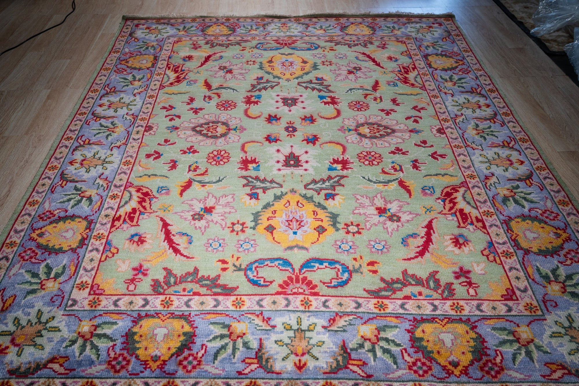 Light green Oushak floral wool rug, angled full view