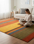 Multicolor striped Gabbeh handmade wool area rug styled in a living room