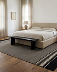 Black and Beige Stripe Handmade Wool Rug styled in a bedroom