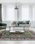 A traditional green, blue, and pink patterned rug anchors a living room with a cream sofa and green chair.