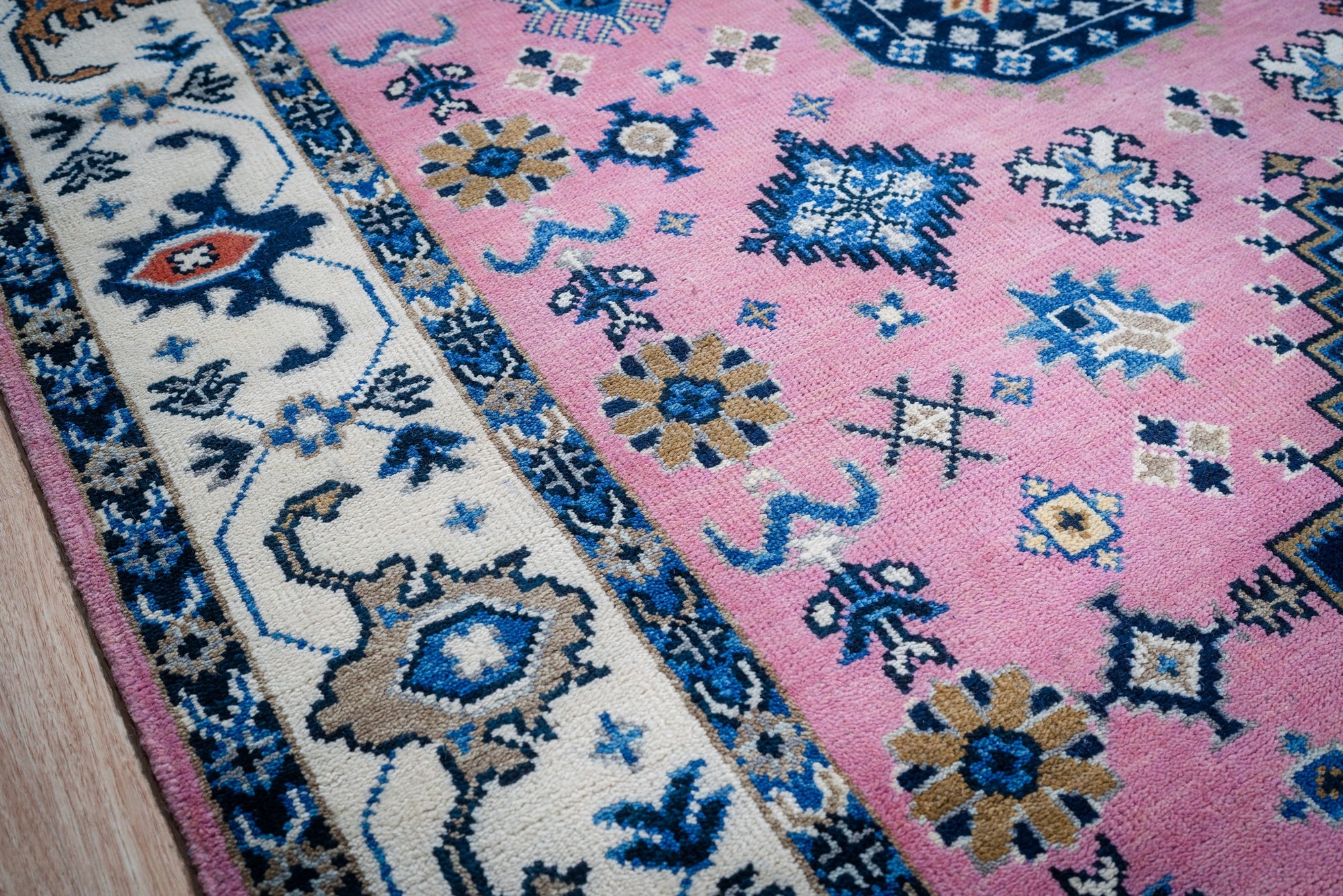 Pink ivory Kazak rug corner and border detail