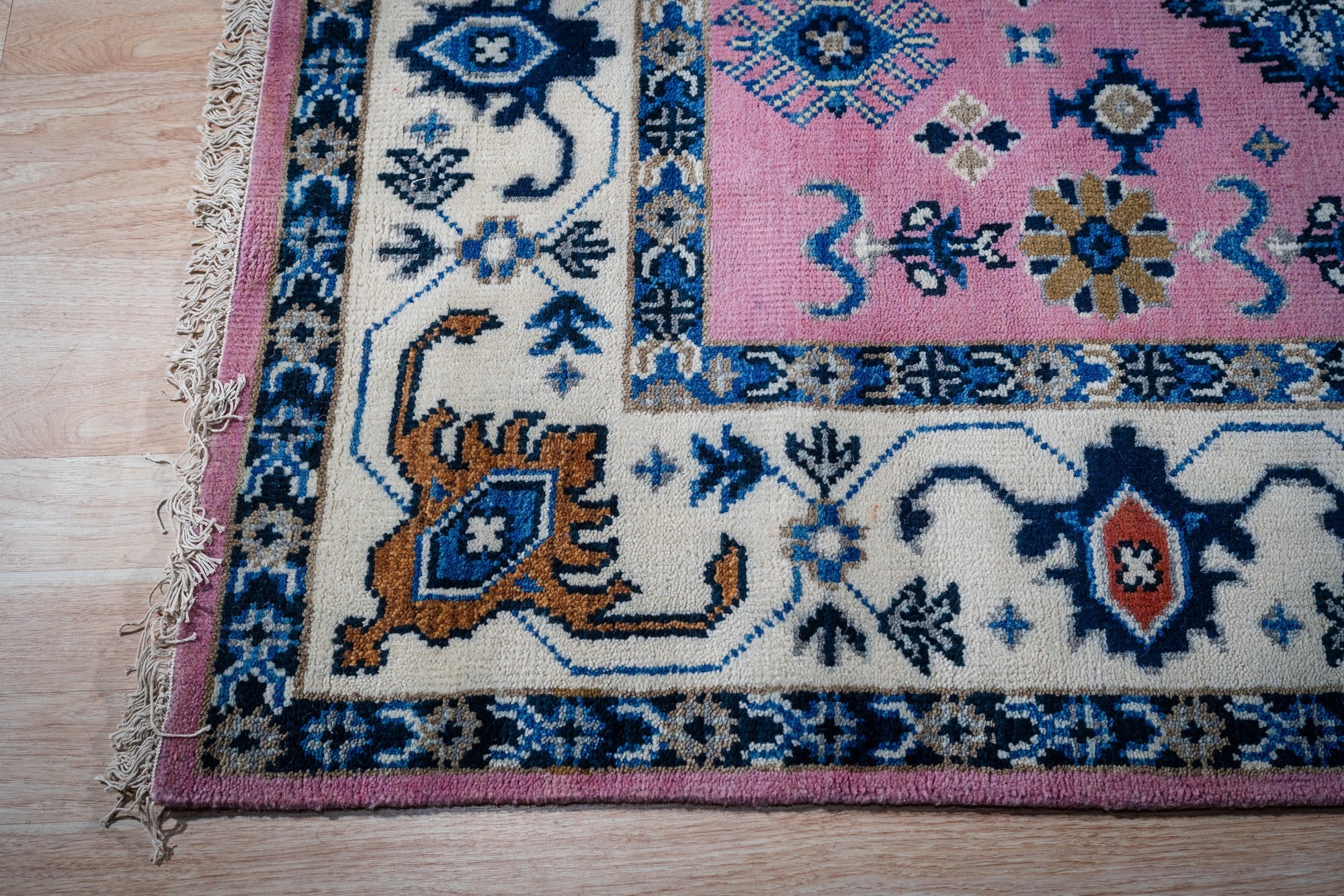 Pink ivory Kazak rug corner detail with ivory border