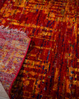 Sari-silk red abstract Anand rug corner folded showing the back