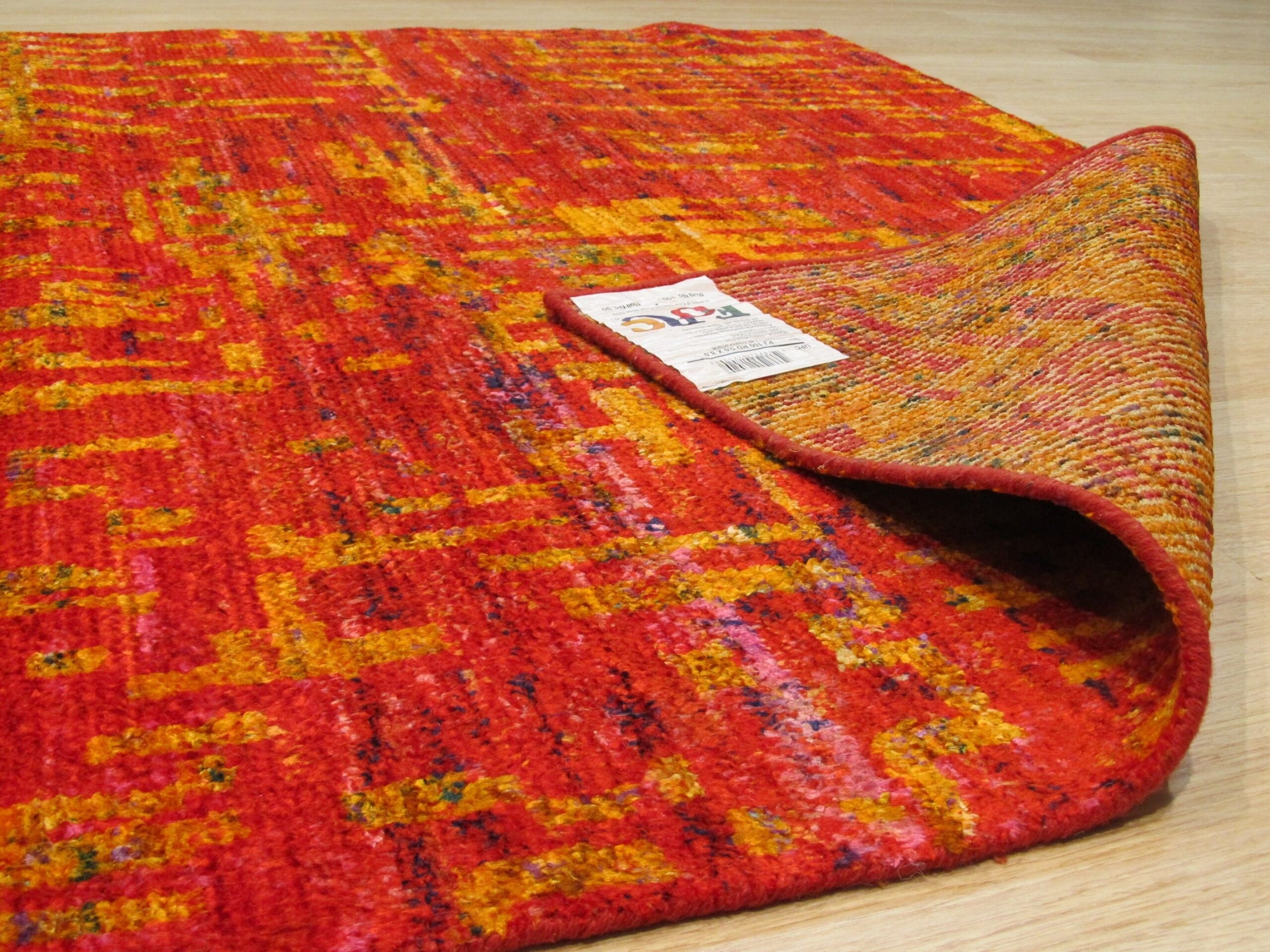 Anand rug folded corner showing the hand-knotted back and label