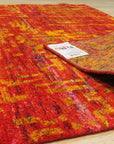 Anand rug folded corner showing the hand-knotted back and label