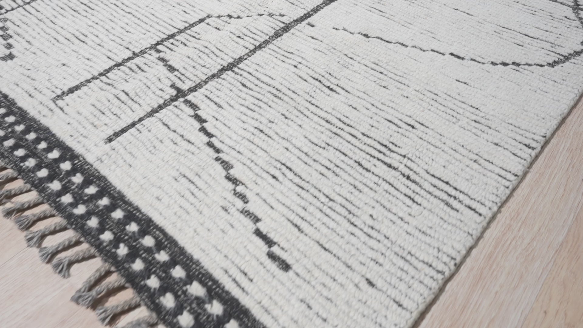 Refined Marrakech Ivory Hand-Knotted Wool Rug, a creamy ivory wool rug with a subtle, geometric Moroccan-inspired pattern, displayed on a light wood floor, suggesting warmth and understated elegance.