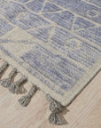 Elegant Marrakech Blue Hand-Knotted Wool Rug, with vibrant blue and cream geometric patterns, enriching a warmly lit living space.