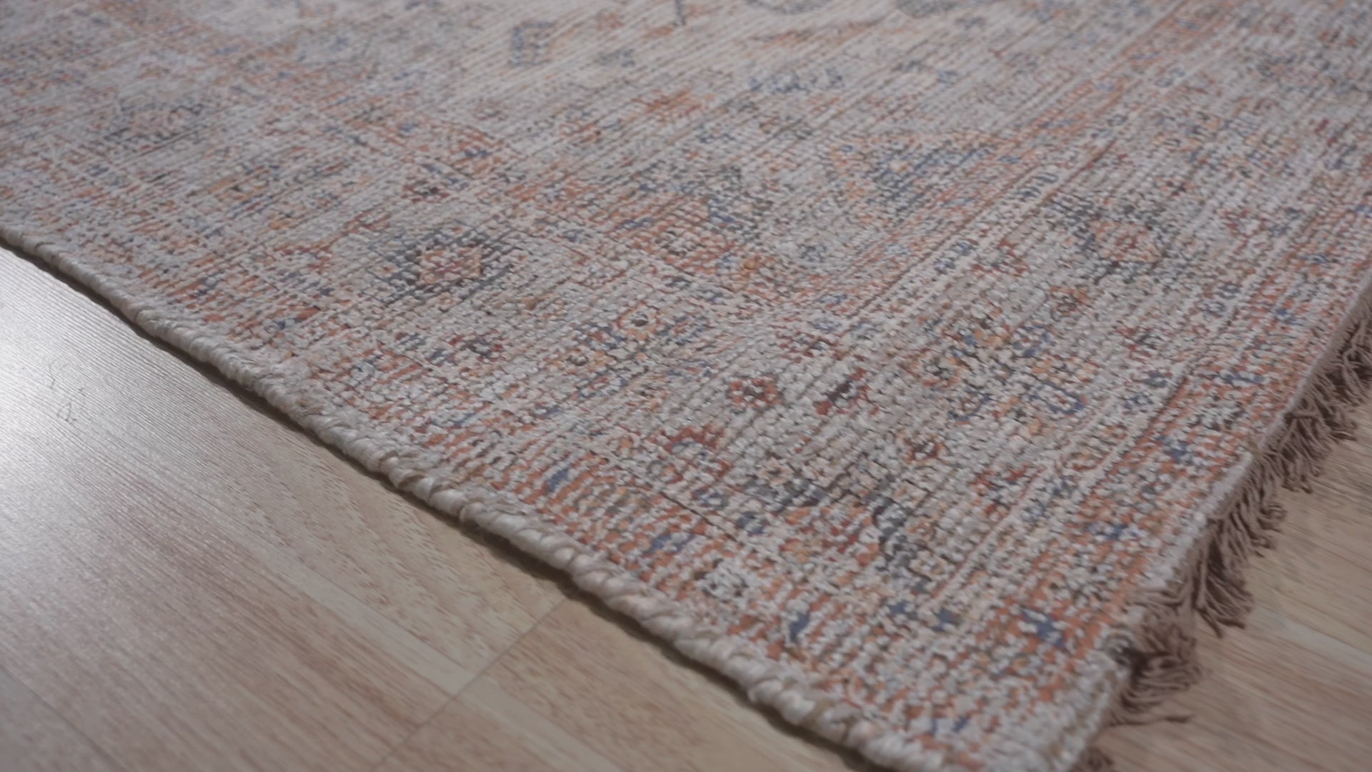 Refined Fiona Blue Handmade Wool Rug, seen with a blurred background, hints at its elegant blue tones and plush wool construction, suggesting a luxurious feel underfoot.