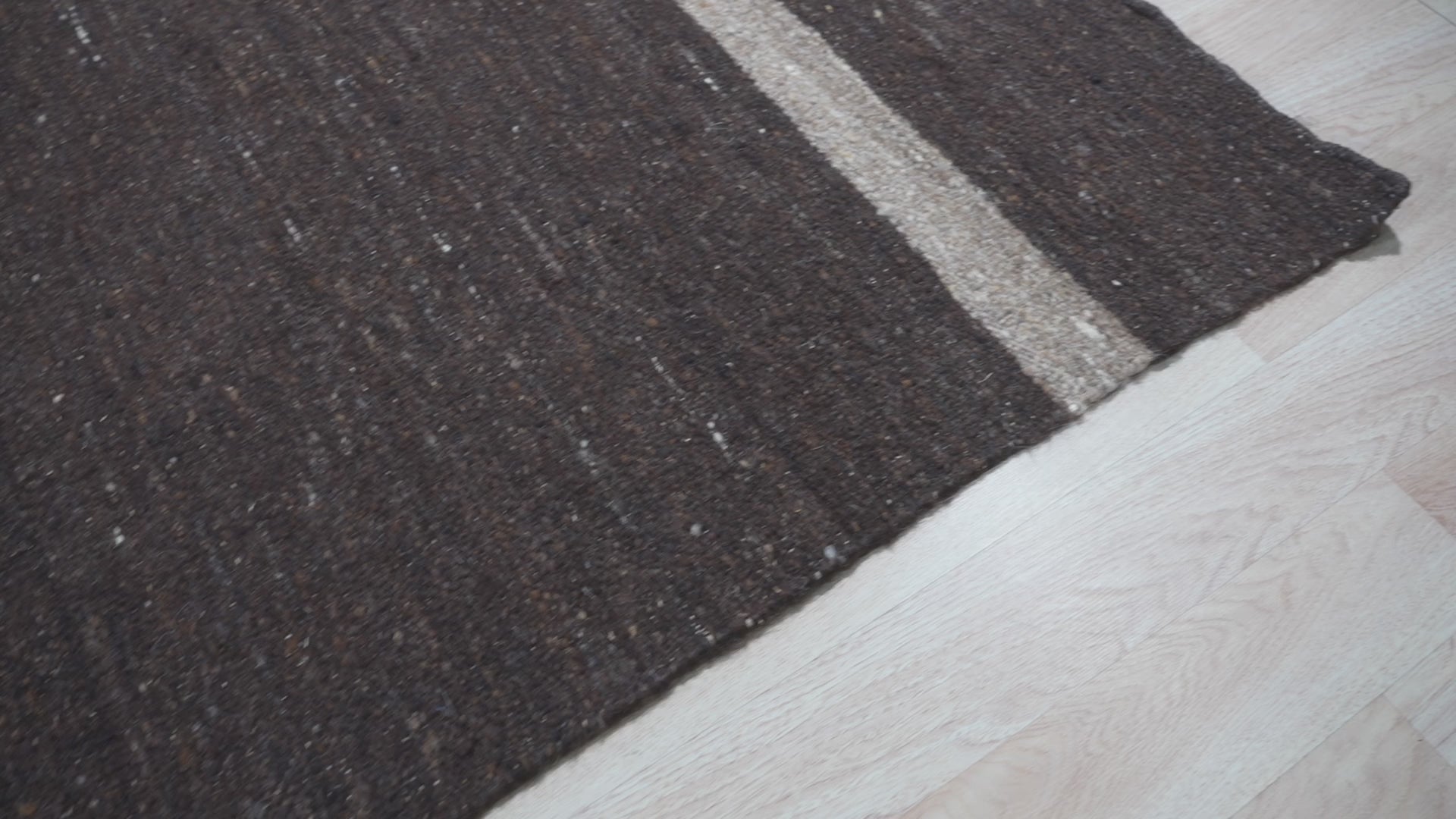Violet Artistic Brown Flatweave Wool Rug, a blend of earthy browns and violet hues creates an artistic statement underfoot, seen within a modern living space.