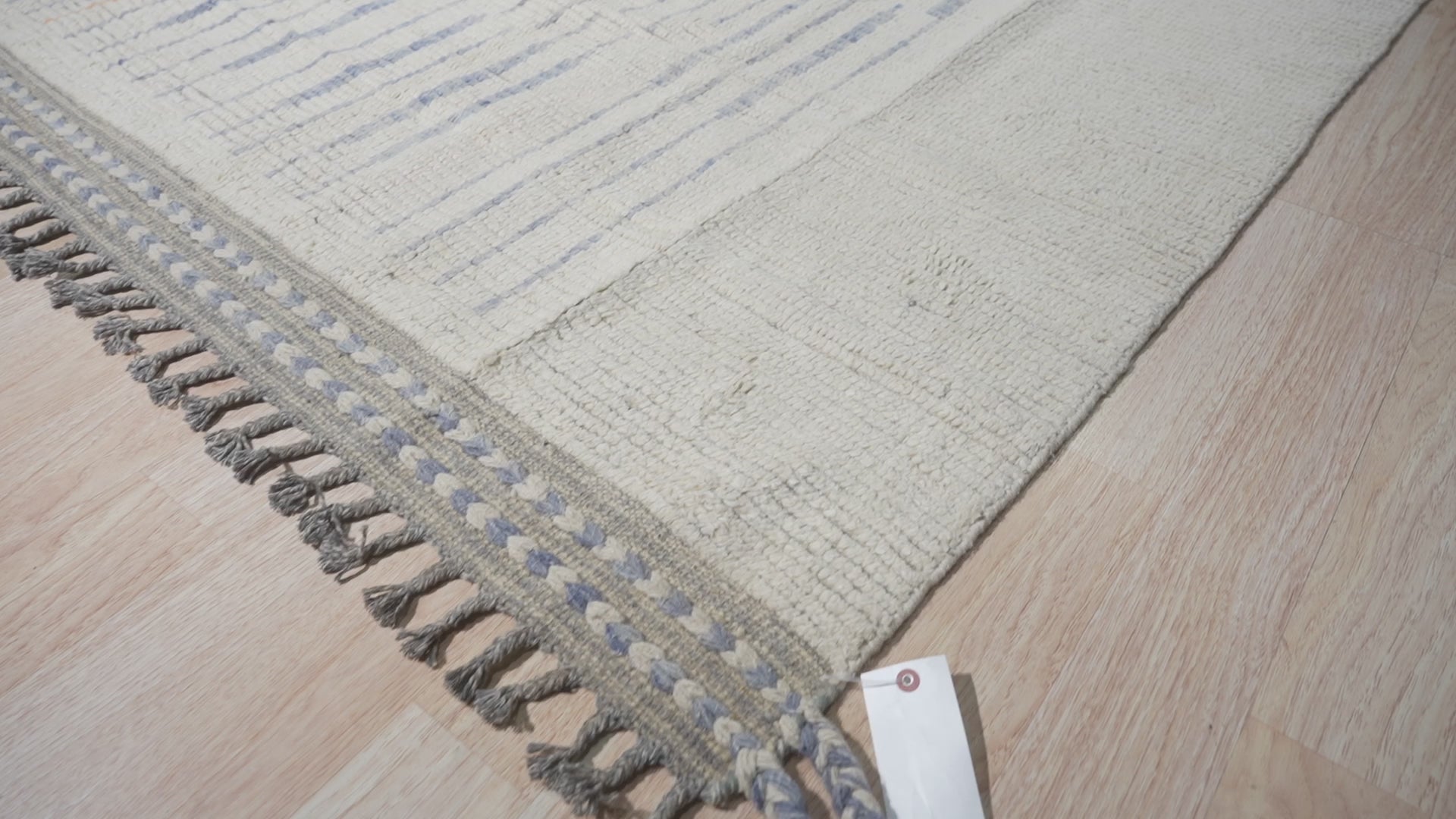 Abstract Marrakech Ivory Hand-Knotted Wool Rug, its organic ivory tones and subtle abstract design complementing a bright, modern living space.