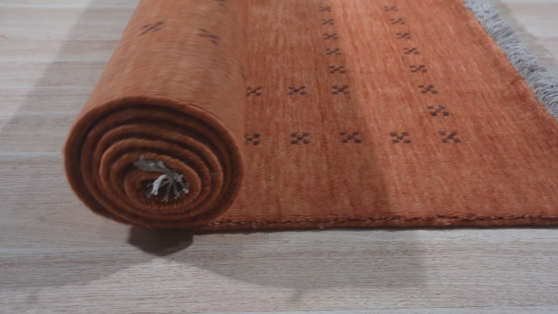 Given the image position is 12, the alt text should be:
 
 "Jasmine Alluring Orange Handmade Wool Rug, a vibrant orange wool rug likely within a styled room setting, showcasing its construction and color."