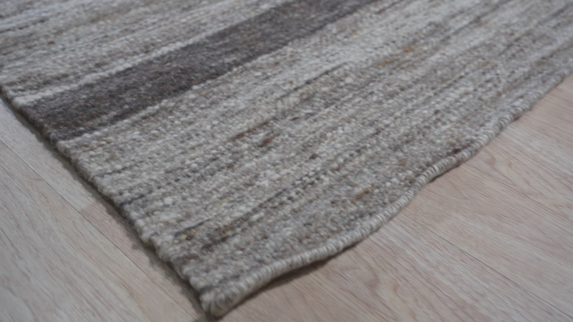 Lila Violet Light Gray Flatweave Wool Rug, blending subtly in a warmly lit living space with modern furniture. Soft violet and light gray hues complement the light wood flooring, showcasing the flatweave construction.