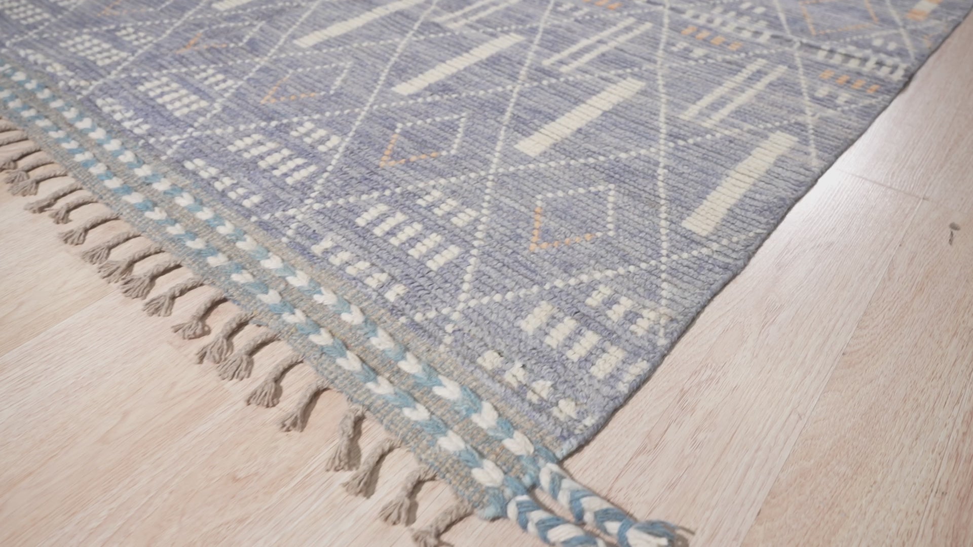 Decorative Marrakech Ivory Hand-Knotted Wool Rug displayed in a living room setting. Ivory hues and hand-knotted wool construction create a soft, inviting texture beneath furniture.