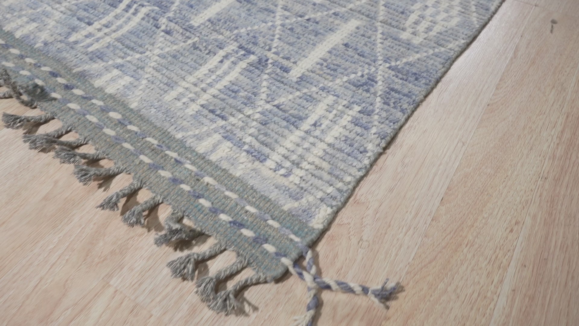 Refined Marrakech Blue Hand-Knotted Wool Rug, displaying rich indigo and cream patterns; hand-knotted wool rug anchors a warmly lit living space with neutral furnishings.