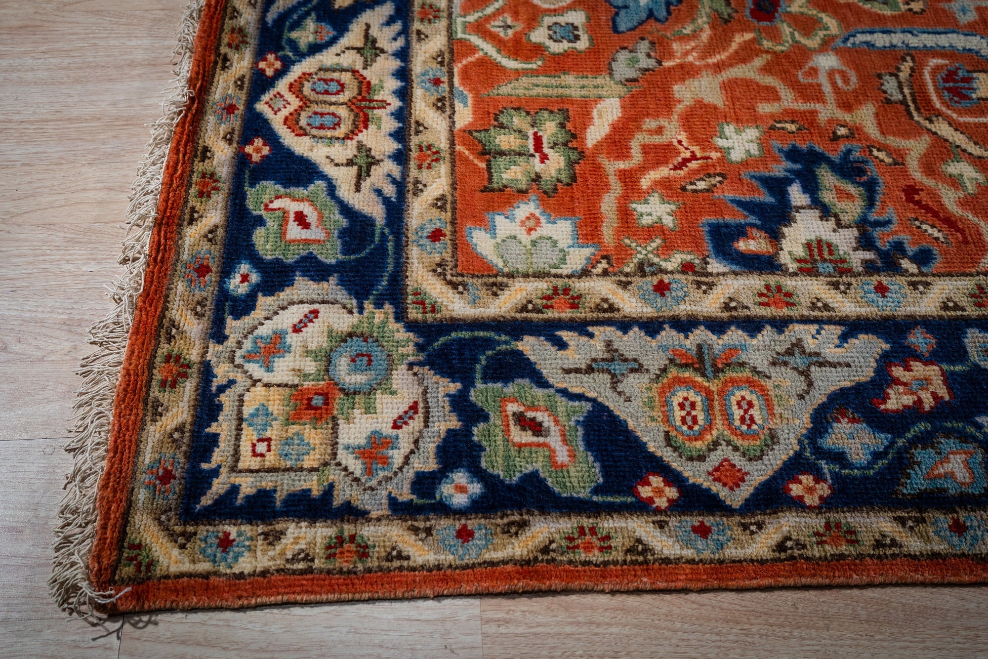 Rust Oushak rug corner and navy border detail
