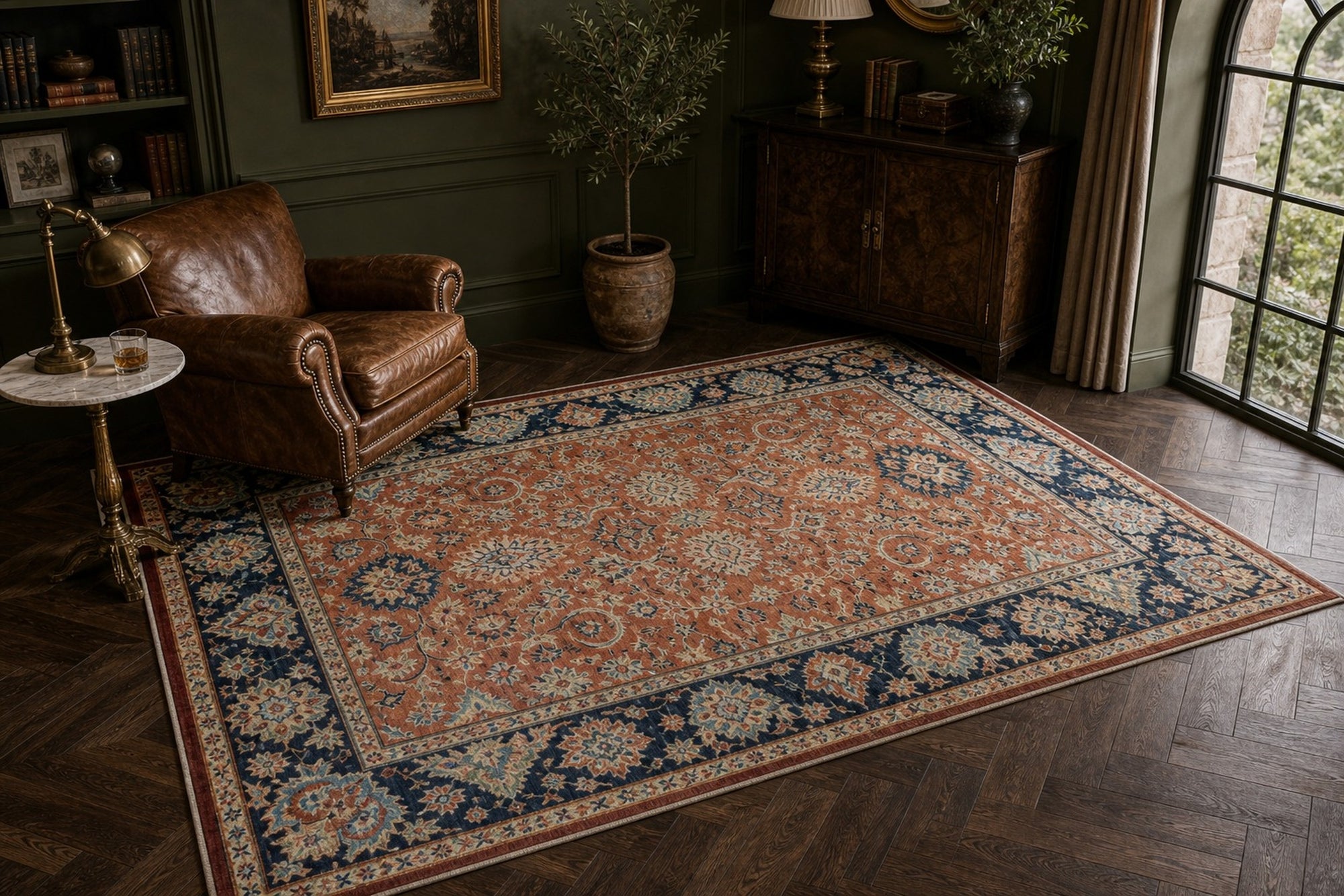 Rust Oushak floral rug styled in a green library with a leather chair